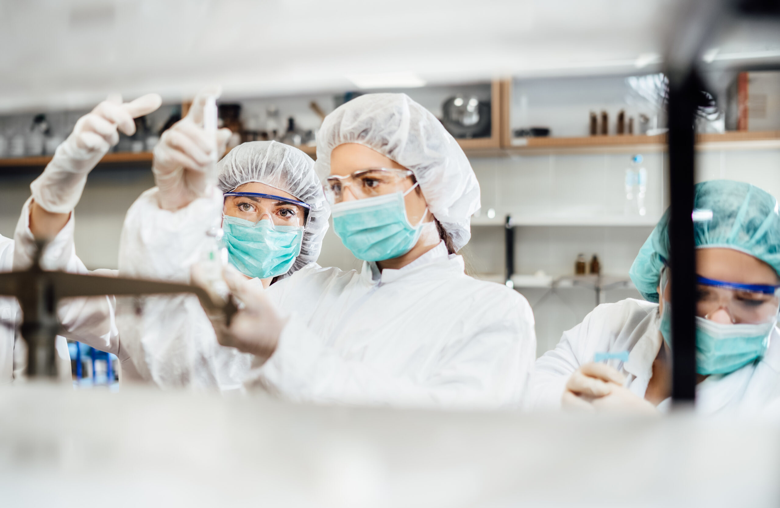 Team of pharmacist working on drug discovery.Development of new vaccine.Sterile cleanroom.Antivirus antidote immunization concept.Lab pre-clinic experiment.Disease biochemical analyisis.Diagnostics